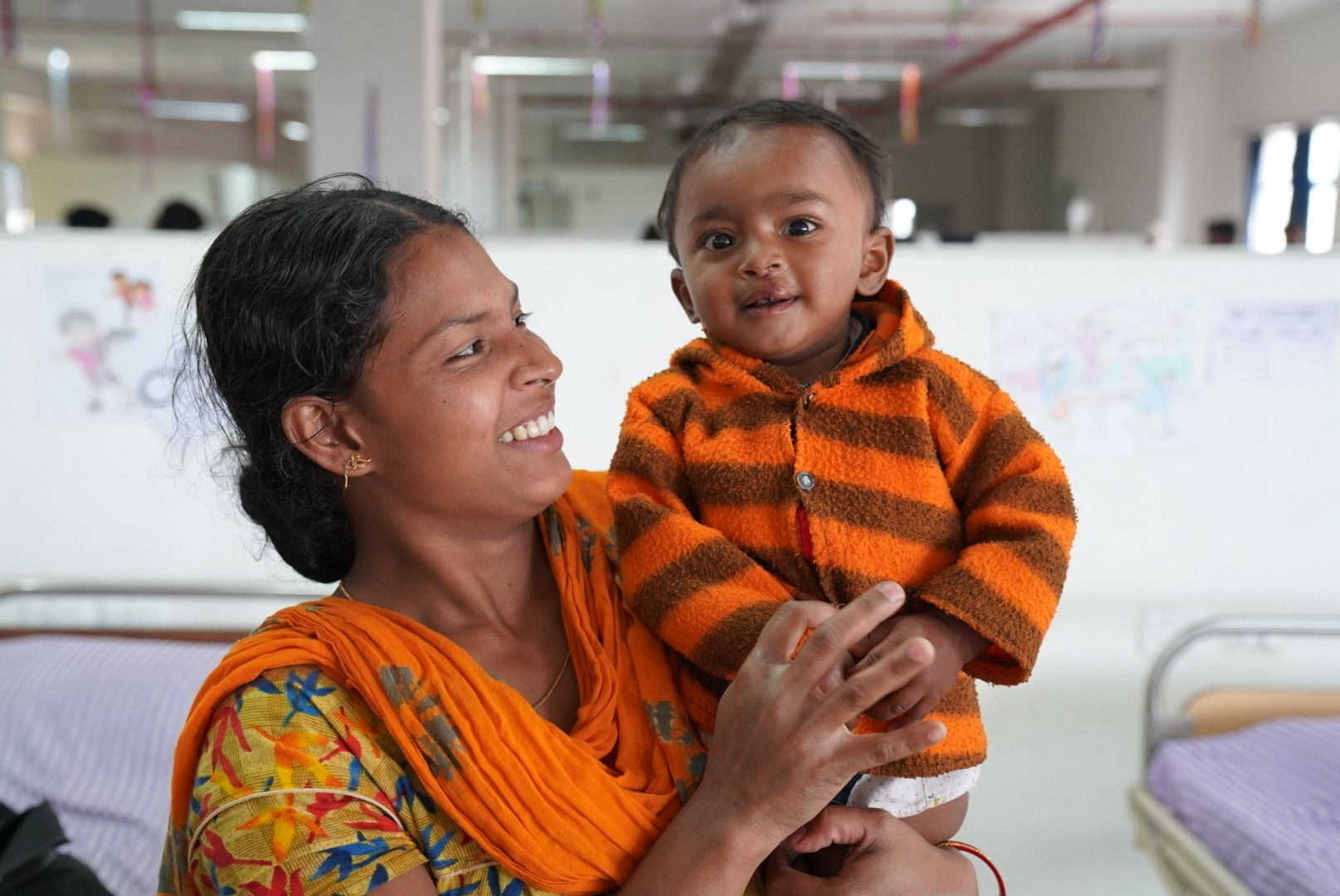A mother smiling at her baby in a health facility