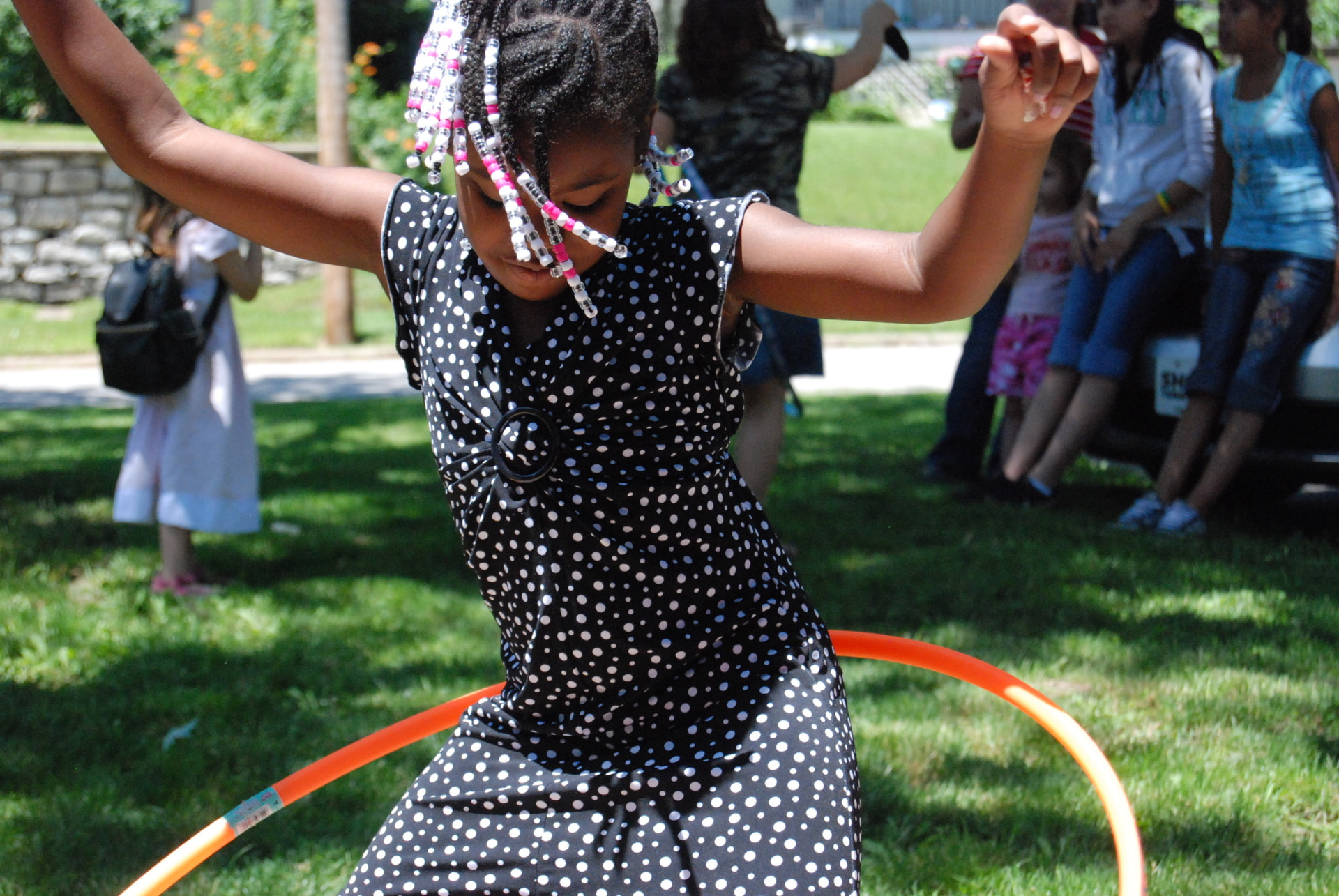 A girl playing with a hula hoop outdoors
